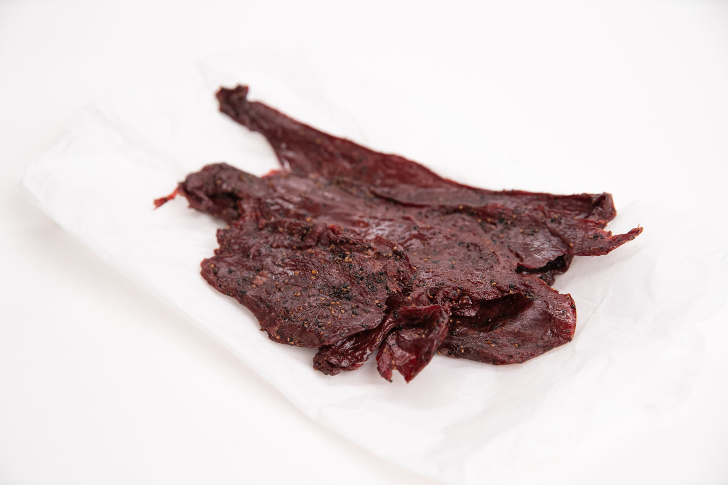 Dried elk jerky on a white background
