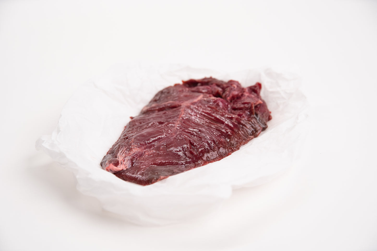 Raw elk meat on a white background