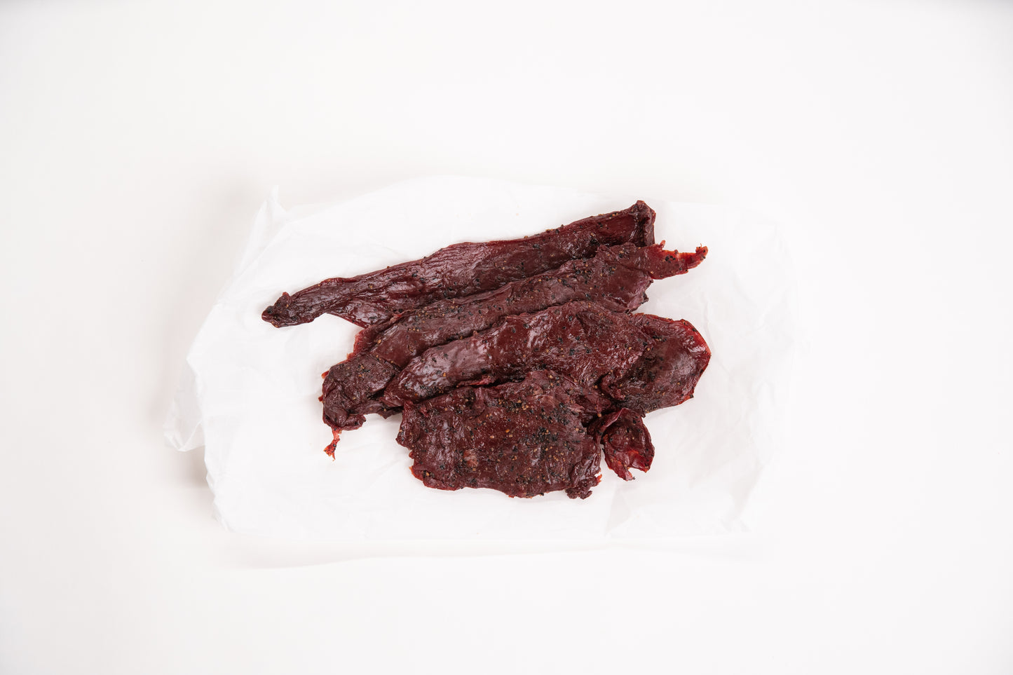 Dried elk jerky on a white background