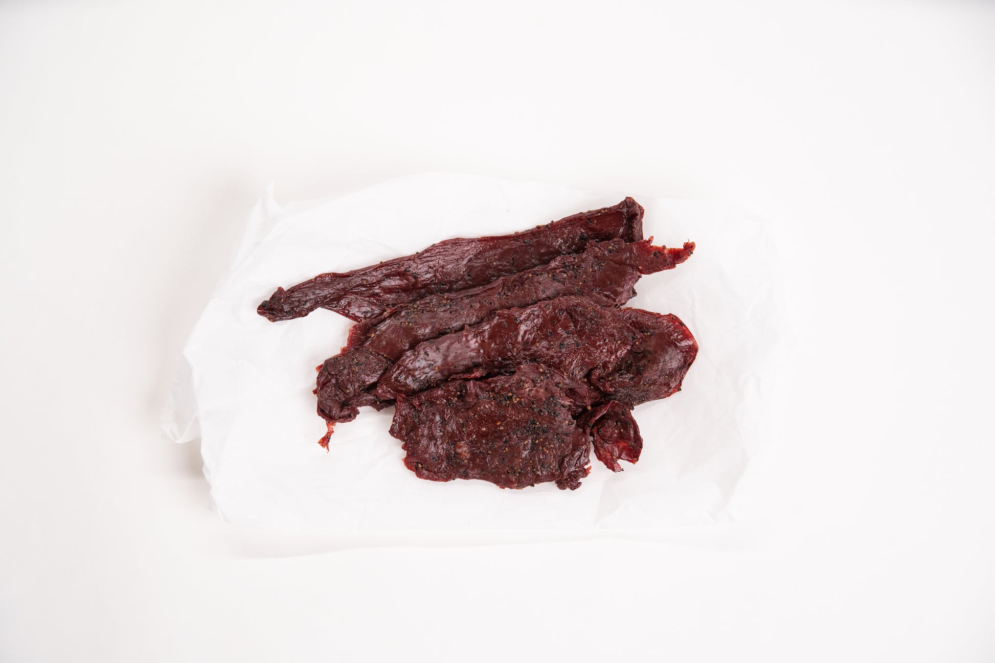 Dried elk jerky on a white background