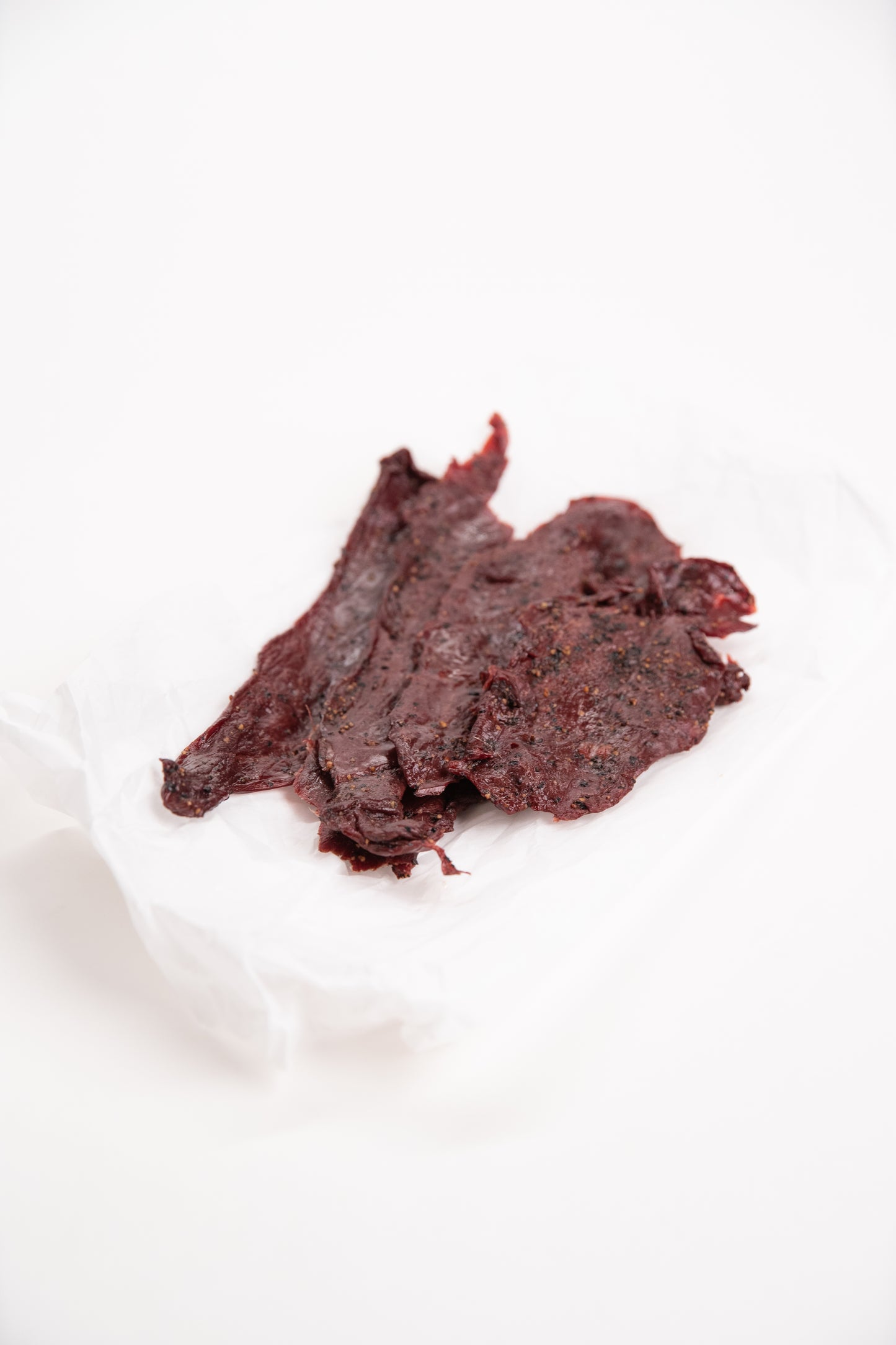 Dried elk jerky on a white background