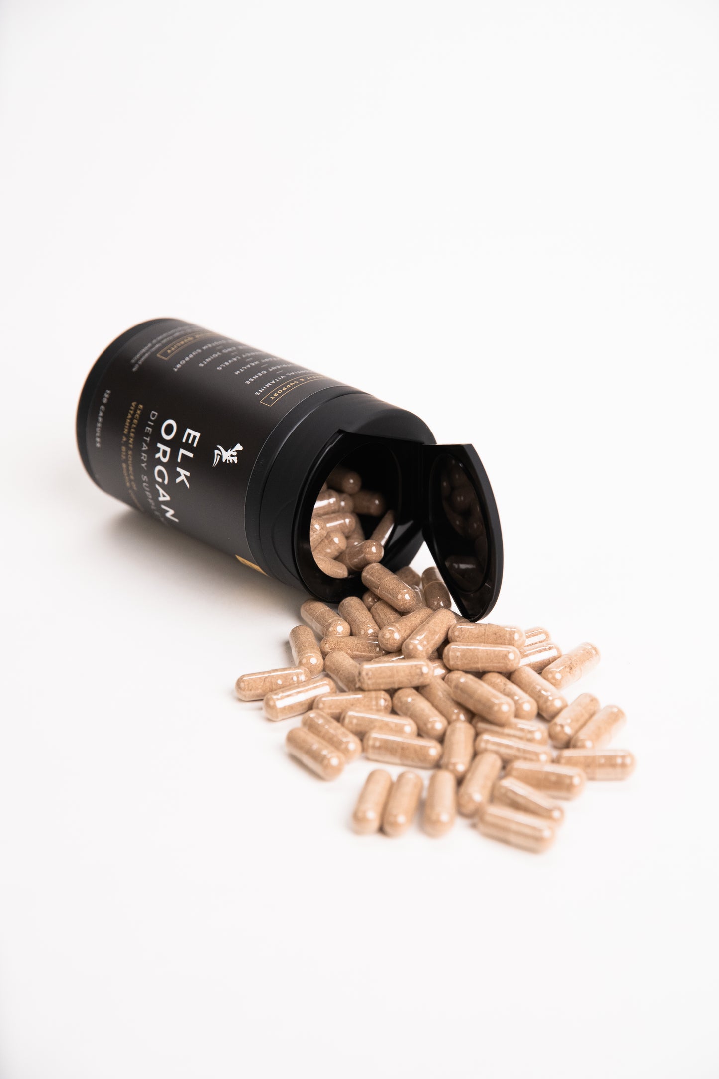 Elk Organ Dietary Supplement with capsules pouring out of black bottle