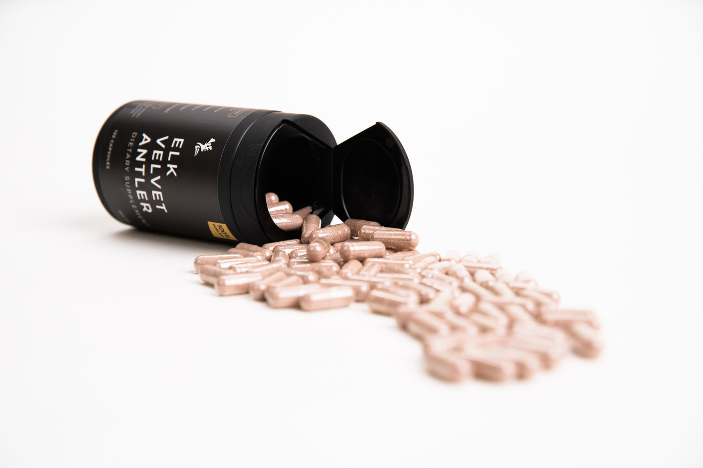 Elk Velvet Antler Dietary Supplement with capsules pouring out of black bottle