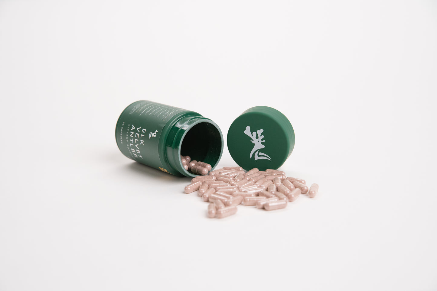 Elk Velvet Antler Dietary Supplement with capsules pouring out of green bottle