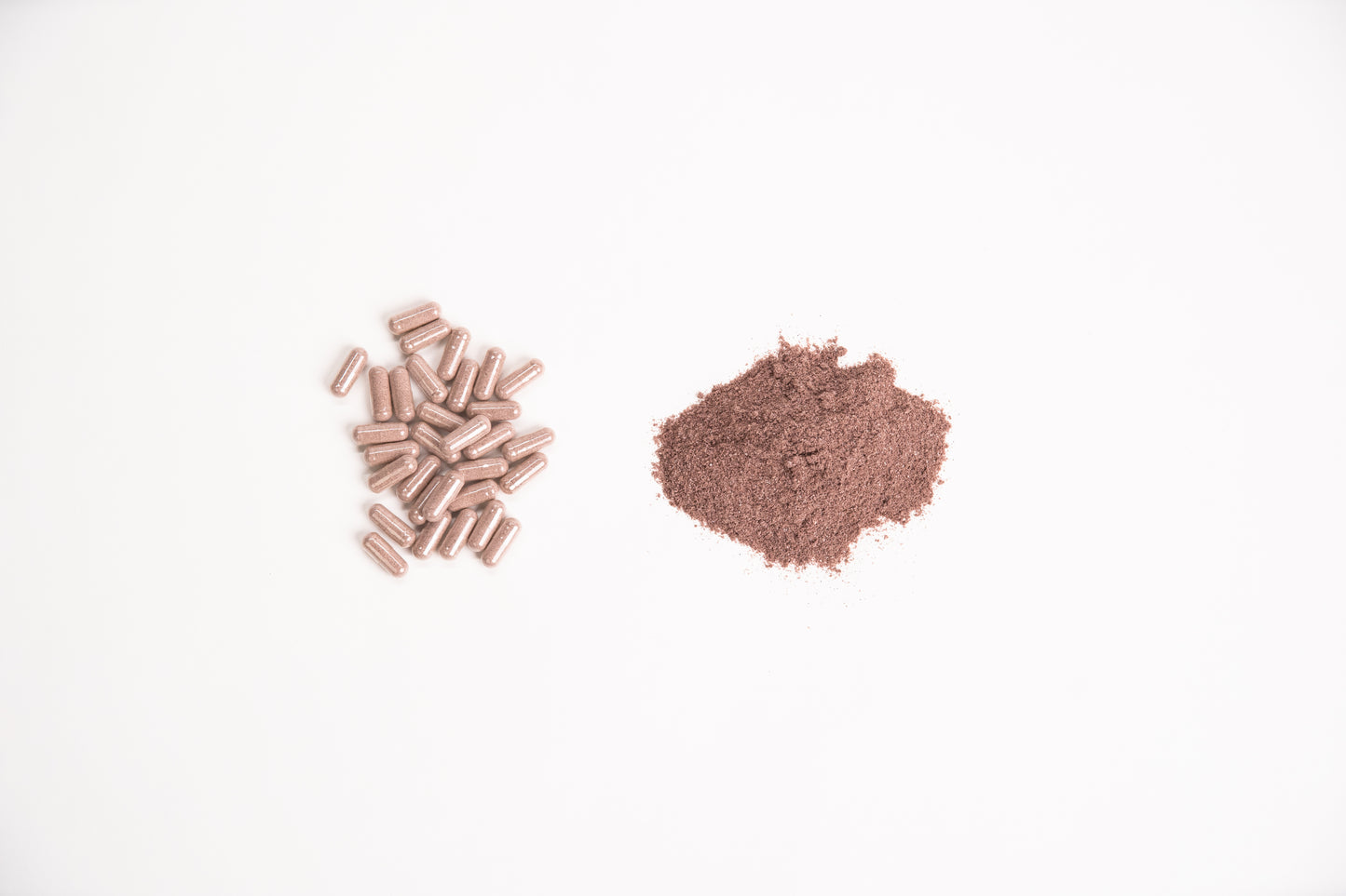 Elk Velvet Antler Dietary Supplement capsules next to small mound of supplement powder
