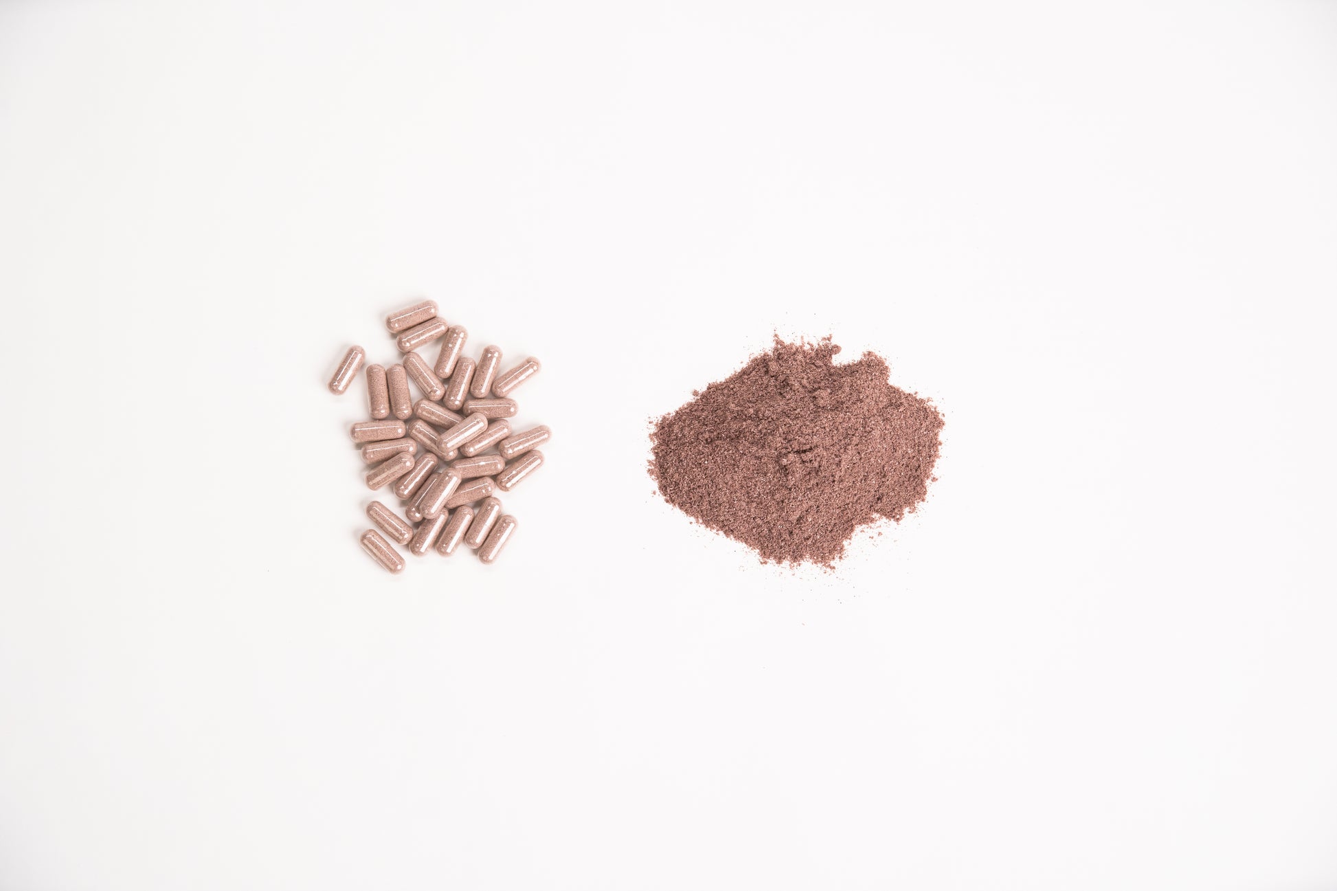Elk Velvet Antler Dietary Supplement capsules next to small mound of supplement powder